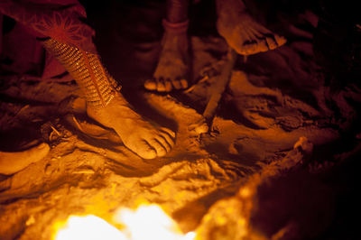 Low section of himba people by bonfire during traditional ceremony at night
