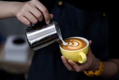 Midsection of person preparing coffee