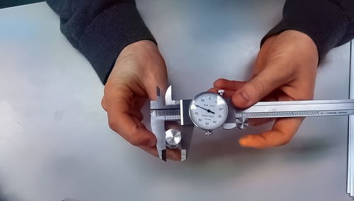 Midsection of person holding clock against wall