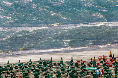 Parasols and deck chairs at beach against sea