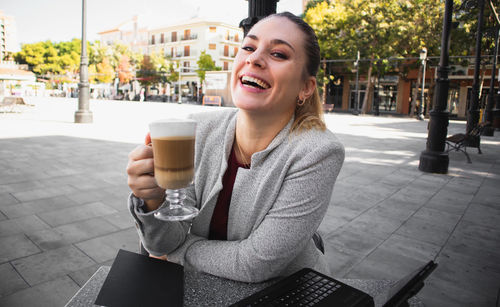 Young woman drinking coffee at cafe