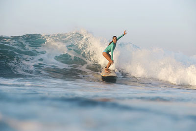 Full length of man surfing in sea against sky