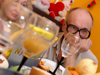 Sad mature couple with food and drink at table in restaurant