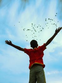 Low angle view of man flying against sky