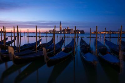Gondolas moored at dock with santa maria della salute in background 