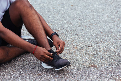 Low section of person holding skateboard on road