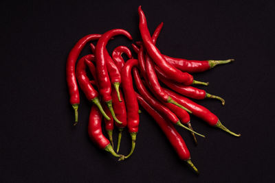 Close-up of red chili peppers against black background