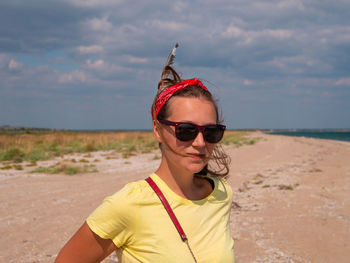 Smiling young boho woman feather in hair on beach european girl in red bandana tribal bohemian style