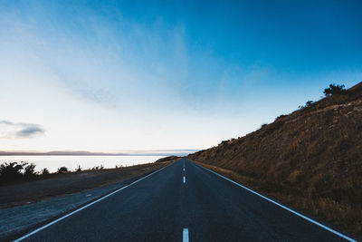 Empty road along countryside landscape