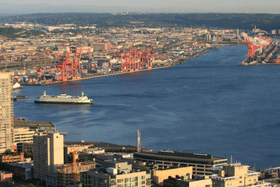 Tourist boat and logistic cargo ship loaded in the seattle harbor container terminal, washington