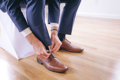 Low section of man standing on hardwood floor