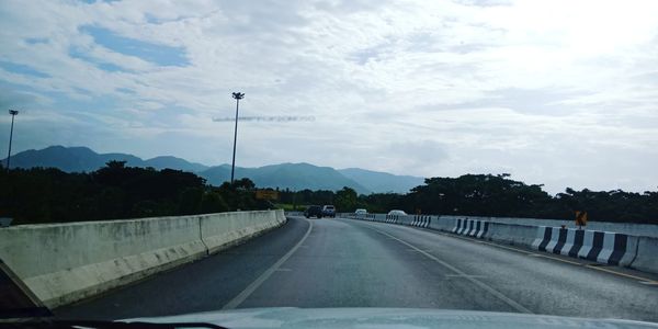 Road against sky seen through car windshield