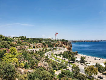 High angle view of townscape by sea against clear blue sky