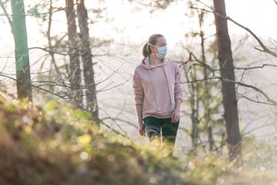 Full length of woman standing in forest