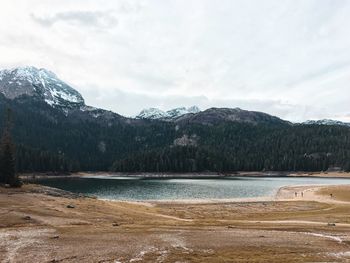 Scenic view of lake by mountains against sky