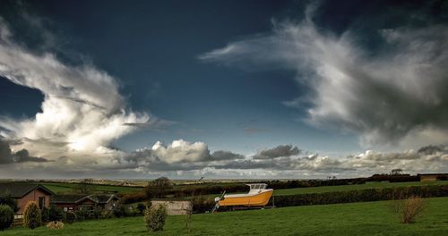Scenic view of field against cloudy sky