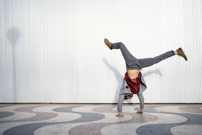 Male entrepreneur doing handstand on footpath