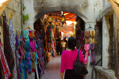 Rear view of woman walking on street at market