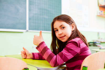 Portrait of cute girl sitting on table