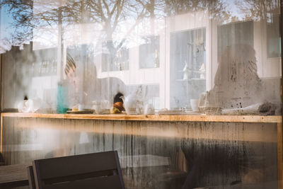 Reflection of man sitting on glass window