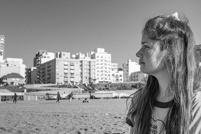 Portrait of woman on beach against sky