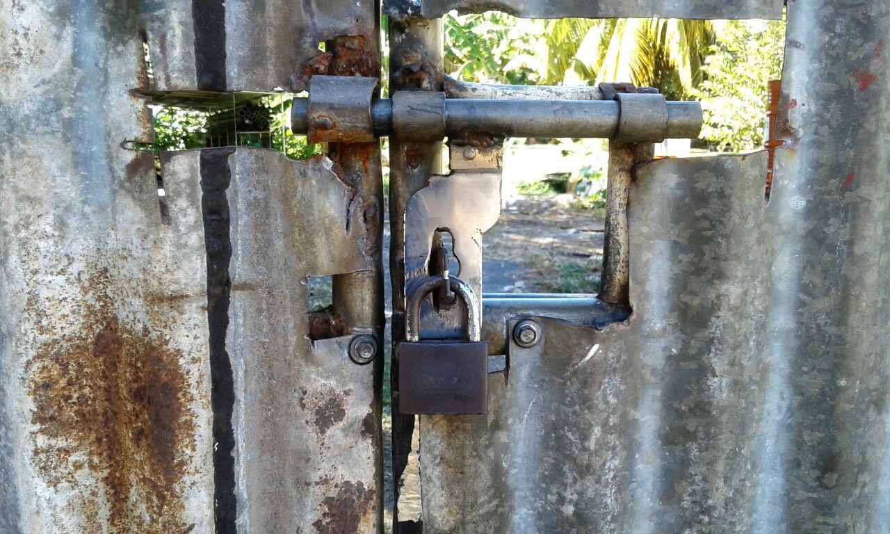 CLOSE-UP OF PADLOCK ON METAL DOOR