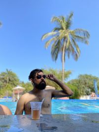 Full length of young man in swimming pool against sky