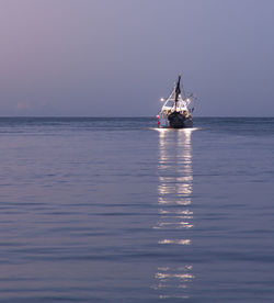 Sailboat sailing on sea against sky