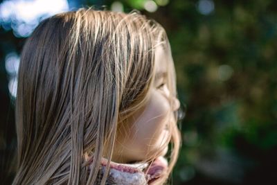 Close-up of small girllooking away in sunlight. 