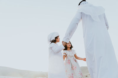 Happy family playing on sand dune