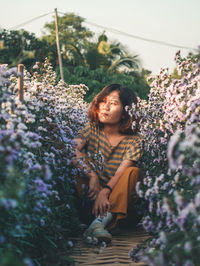 Woman sitting on purple flowering plants