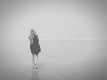 Rear view of woman looking at sea against sky