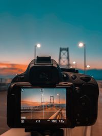 Close-up of camera against sky during sunrise