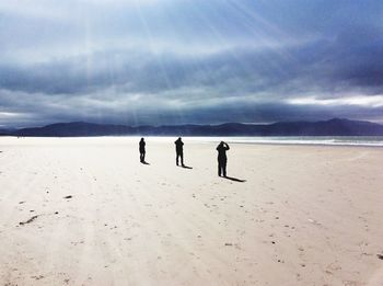 People on beach against sky