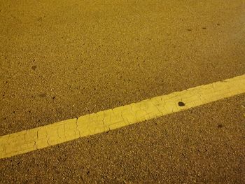 High angle view of yellow arrow symbol on road