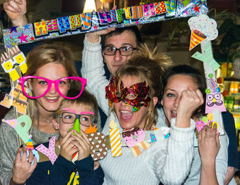 Portrait of happy family wearing novelty glasses and decoration during birthday celebration