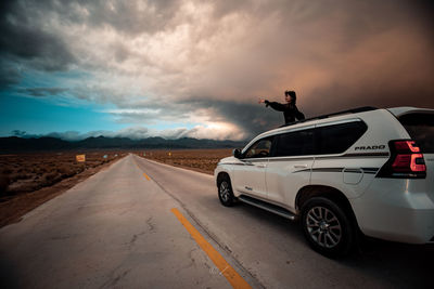 Car on road against sky during sunset