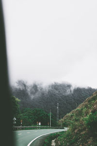 Road leading towards mountains against sky