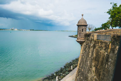 Scenic view of sea by building against sky