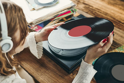 Young woman listening to music from vinyl record player. playing music on turntable player. retro