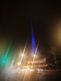 Low angle view of illuminated ferris wheel against sky at night