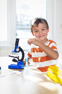 Portrait of smiling boy doing science experiment at home