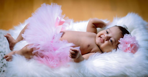 High angle view of newborn baby lying on bed