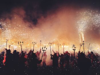 Silhouette people with fireworks during traditional festival