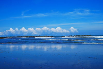 Scenic view of beach against blue sky