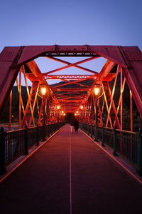 Illuminated footbridge against clear sky