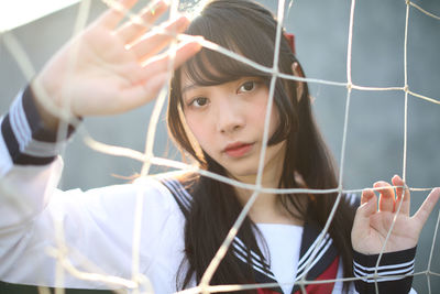 Portrait of woman behind sports net