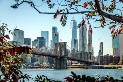 Low angle view of brooklyn bridge over river against clear sky in city