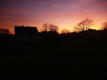 Silhouette house against sky at sunset