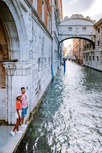 Full length of couple standing by canal